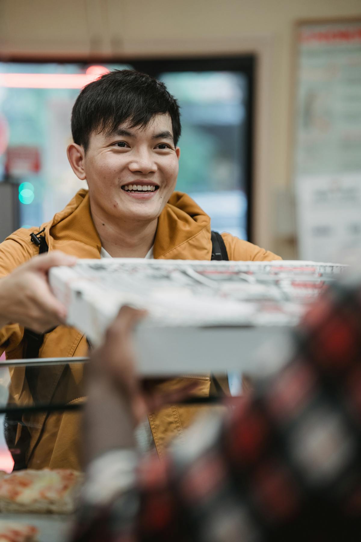Cliente sorrindo ao retirar pedido de pizza em restaurante